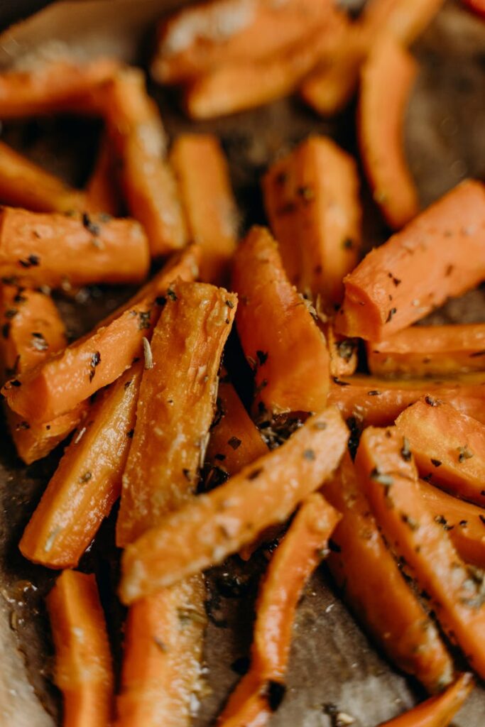 Close-up of seasoned roasted carrot sticks showcasing delicious, healthy food.